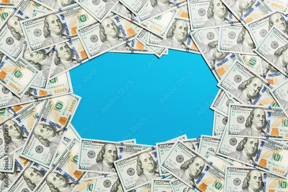 Frame of one hundred dollar bills with empty space for your design. Top view of business concept on blue background with copy space
