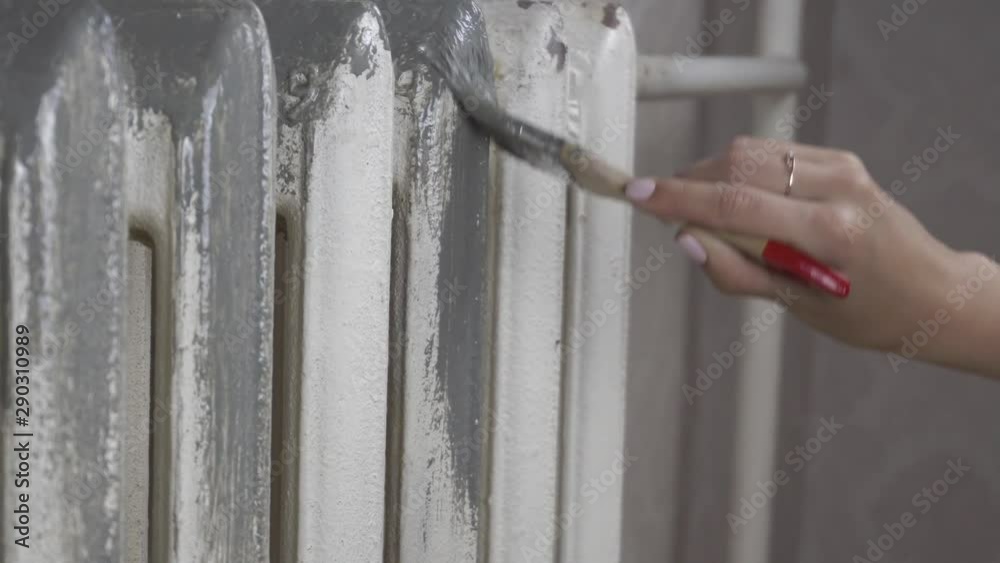 the girl primers the heating batteries before painting
