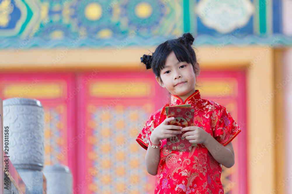 Adorable Chinese girl open golden and red envelopes that contain Chinese word, Xinfu, mean Happiness for Chinese New Year bless Adorable Chinese girl open golden and red envelopes that contain Chinese word, Xinfu, mean Happiness for Chinese New Year bless