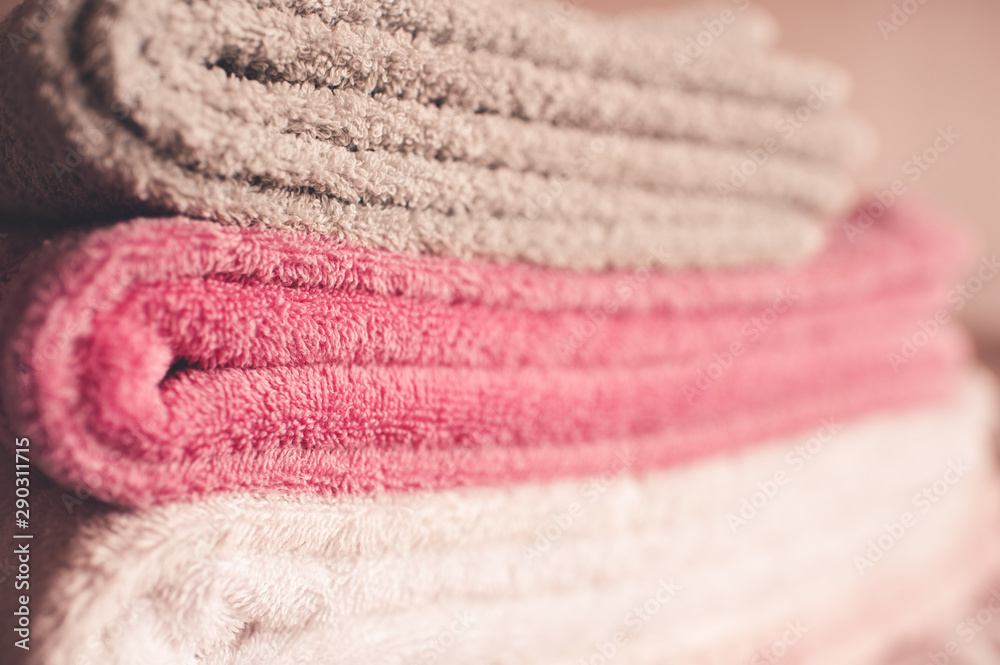 Stack of soft towels staying in bed in hotel room close up. Selective focus. Stack of soft towels staying in bed in hotel room close up. Selective focus.