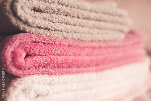 Stack of soft towels staying in bed in hotel room close up. Selective focus. © morrowlight