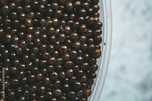 Sturgeon black caviar in can on white background photo