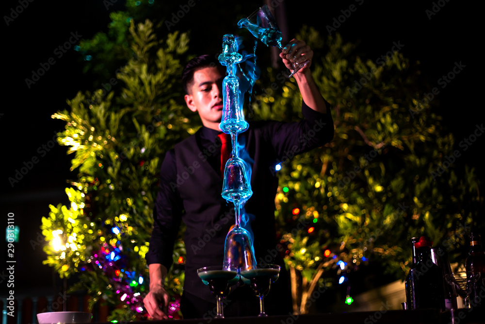 Professional bartender is making flaming lamborghini cocktail at night  party. Photos | Adobe Stock