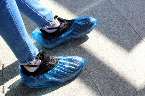 blue disposable shoe covers are worn on the upper shoes photo