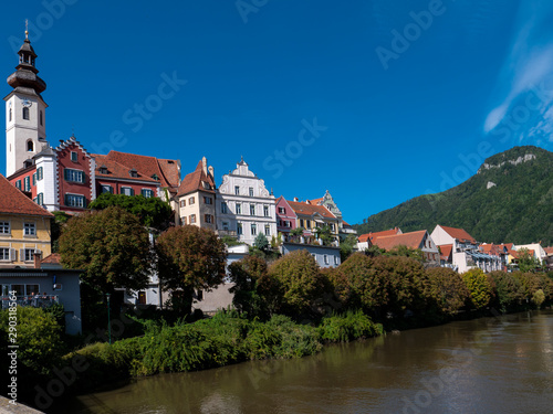 Flusseitige Silouhette von Frohnleiten an der Mur im Bezirk Graz, Österreich mit blauem Himmel, Kirche und historischen Häusern