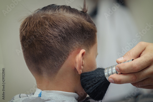 Stylish boy getting hairstyling in barbershop.