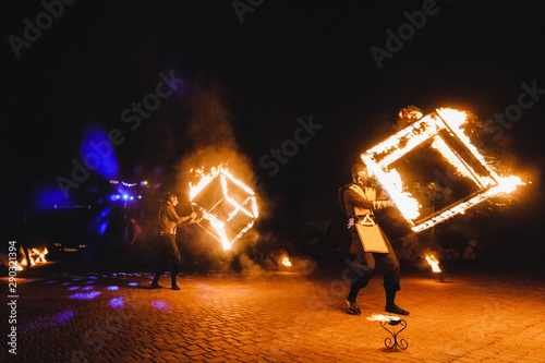 Two man in a suit LED dances with fire night. fire show at a wedding and a lot of the bright sparks. dancing with flame, male masterclass, torch. man fire control, Fire cube. © Serhii