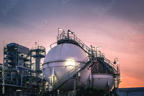 Gas storage sphere tanks in factories on sunset sky background photo