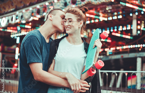 Romantic concept. Beautiful, young couple in love having fun at amusement park.
