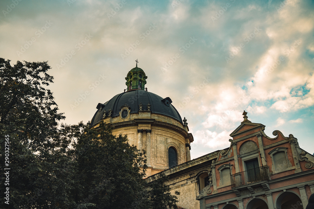 Lviv Ukrainian European medieval city dramatic moody photography of cathedral old stone Gothic architecture style dome on cloudy sky background  