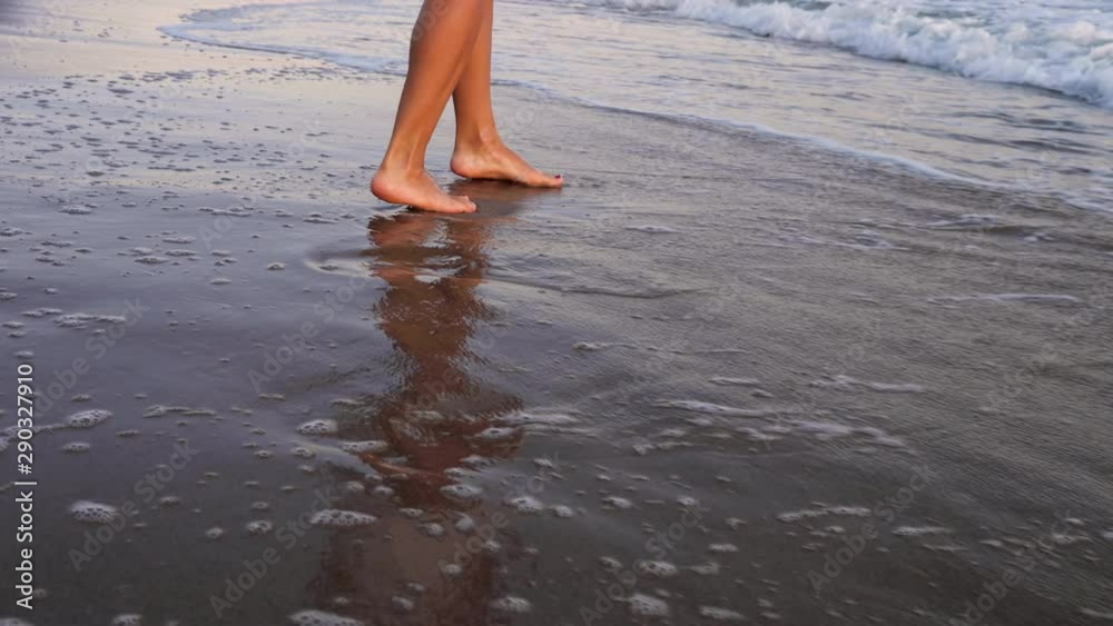 Beautiful woman in a white dress at the beach at sunset Beautiful woman in a white dress at the beach at sunset