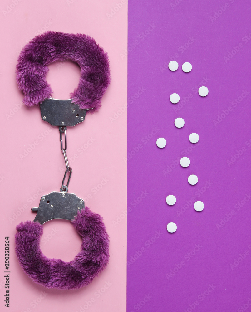 Sex stimulation. Handcuffs for sex games with pills on purple pink  background. Sexual bdsm toy. Fetish, erotic concept. Top view Stock Photo |  Adobe Stock