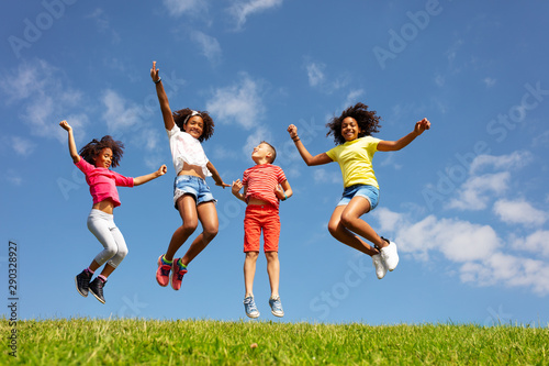 Group of kids jump high over blue sky and clouds