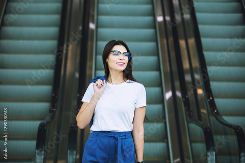 Young adult beautiful brunette girl happy businesswoman on escalator in business center