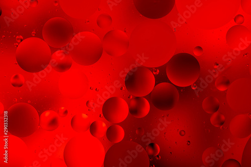 bright oily drops in water with colorful background, close-up