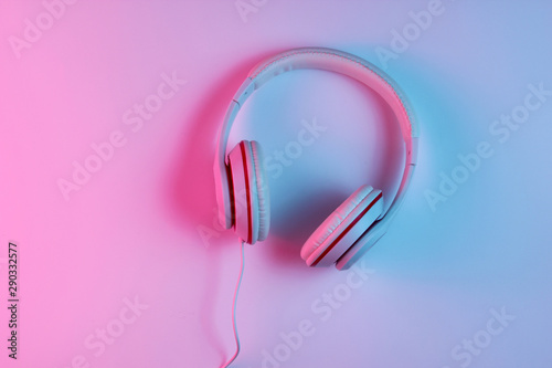Classic wired headphones with gradient blue pink neon light. Retro style.Retro wave. 80s. Minimalistic music concept. Top view