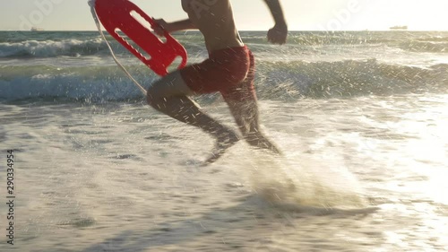 Male lifeguard running along the beach photo