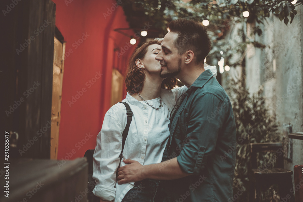 Cheerful cheerful hipster couple in love kissing in a city street. The romantic concept of lovers. love story