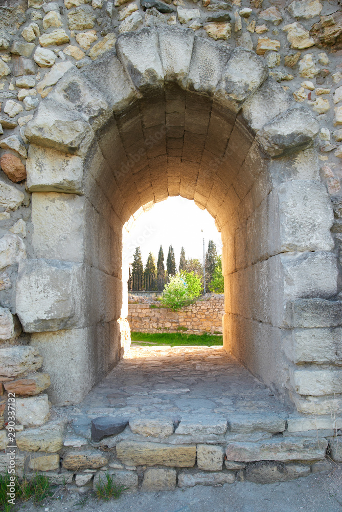 Window in ancient wall. Entrance to green park