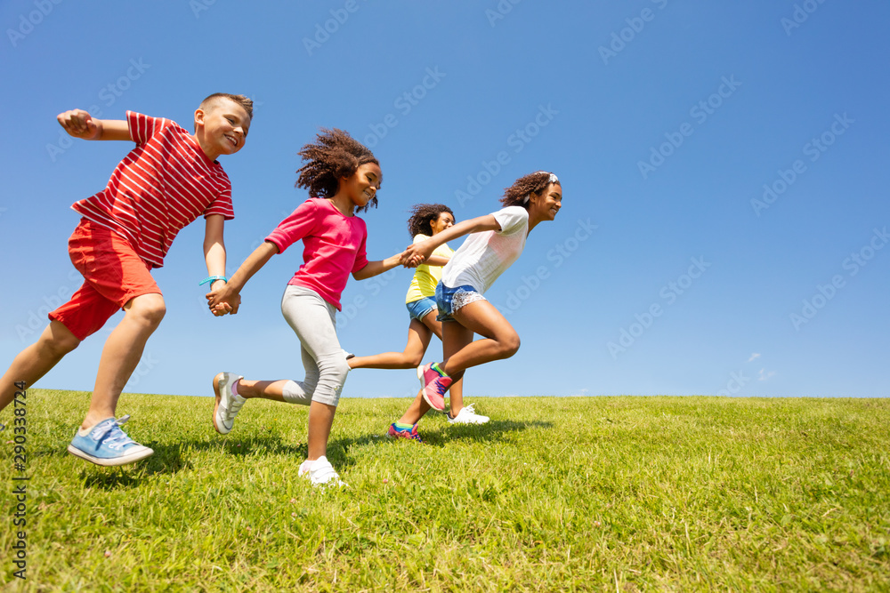 Diverse group of happy kids run in park hold hands - obrazy, fototapety, plakaty 