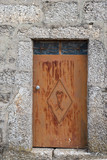 Vieja puerta de hierro pintada de marrón en casa de muros de piedra. Montalegre, Norte de Portugal.