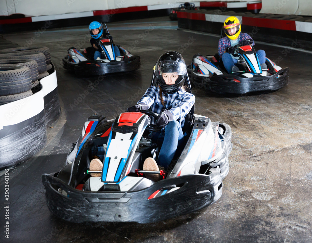 Group of people driving go-carts at racing track