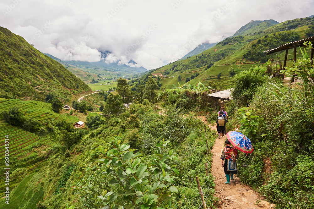 A young mother Black Hmong with baby walking in Muong Hoa Valley, Sa Pa (Lào Cai province,Vietnam)