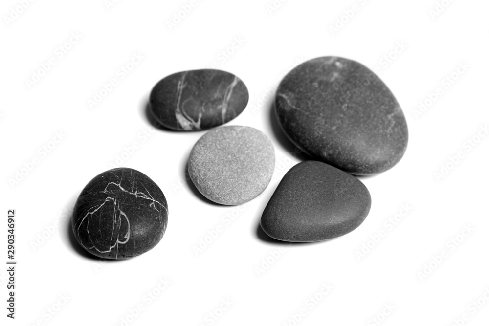 Scattered sea pebbles. Heap of smooth gray and black spa stones isolated on white background Scattered sea pebbles. Heap of smooth gray and black spa stones isolated on white background