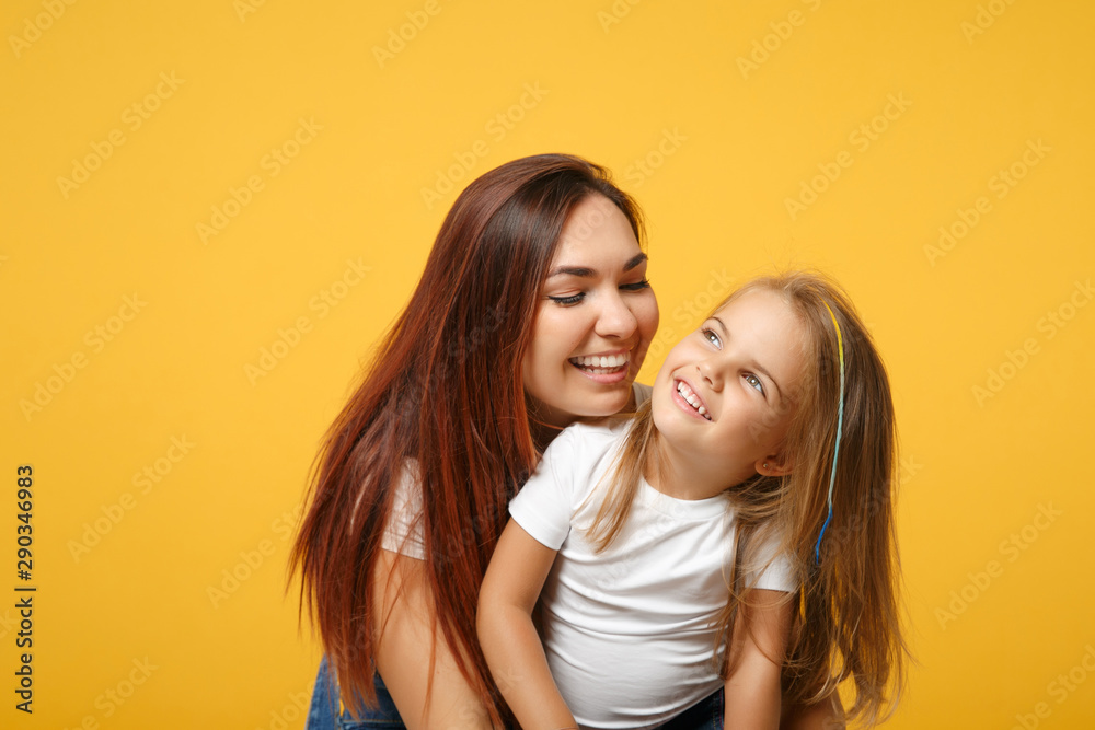 Woman in light clothes have fun with cute child baby girl 4-5 years old. Mommy little kid daughter isolated on yellow background studio portrait. Mother's Day love family parenthood childhood concept. Woman in light clothes have fun with cute child baby girl 4-5 years old. Mommy little kid daughter isolated on yellow background studio portrait. Mother's Day love family parenthood childhood concept.