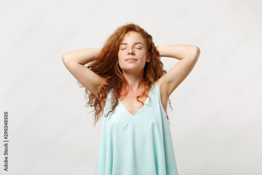 Young relaxed redhead woman in casual light clothes posing isolated on white wall background in studio. People sincere emotions lifestyle concept. Mock up copy space. Sleep with hands behind her head. Young relaxed redhead woman in casual light clothes posing isolated on white wall background in studio. People sincere emotions lifestyle concept. Mock up copy space. Sleep with hands behind her head.