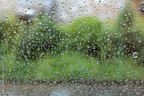 Raindrops on the window. Drops of water or rain drops on window glass with blur buildings background.