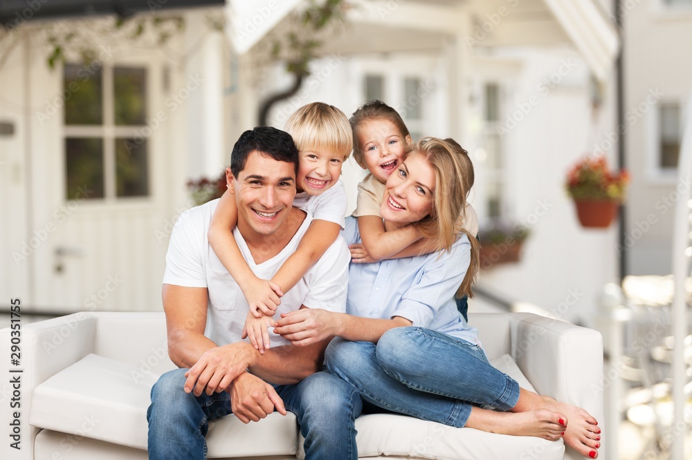 Beautiful smiling family sitting at sofa at home Beautiful smiling family sitting at sofa at home