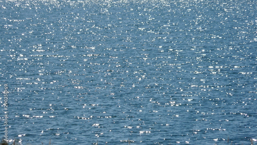 Wasseroberfläche See mit kleinen glitzernden Wellen Wasseroberfläche See mit kleinen glitzernden Wellen