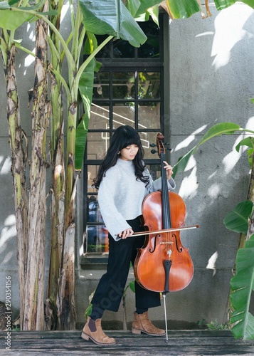 Portraits of female jazz cellist playing in outdoor space