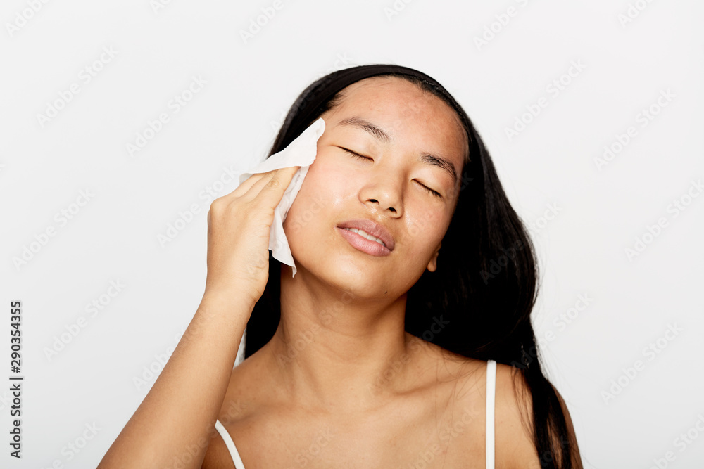 Beautiful young asian woman cleaning her face.
