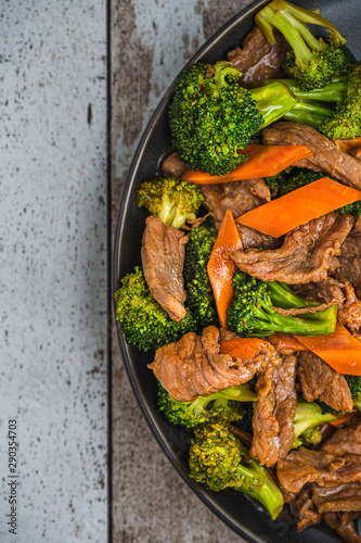 Broccoli Beef with Carrots on a wood background
