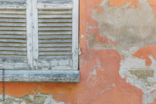 Window shutters in weathered house wall