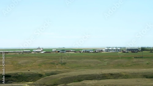Wide zoom in on a Hutterite colony showing the buildings and farming equipment in this self-sustaining religious community.