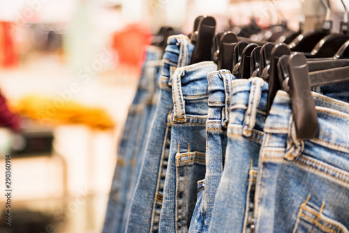 Jeans hang on rails in modern clothes shop © Yakov