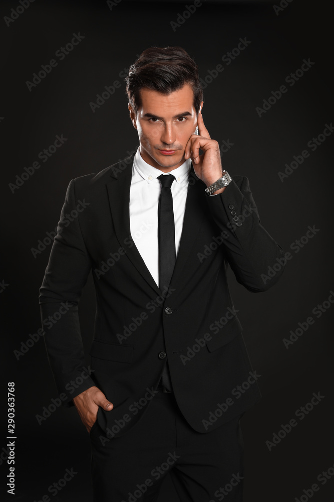 Male security guard in uniform using radio earpiece on dark background Male security guard in uniform using radio earpiece on dark background