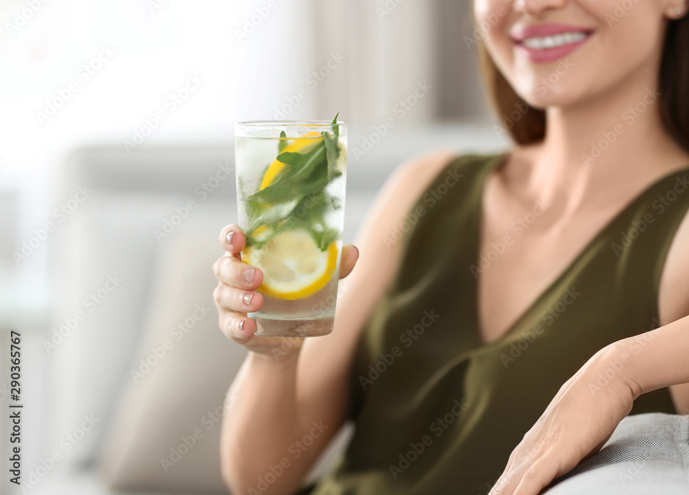 Young woman with lemonade at home, closeup. Refreshing drink Young woman with lemonade at home, closeup. Refreshing drink
