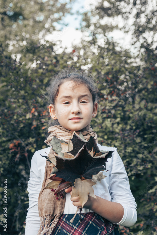Girl holding an autumn bouquet of maple leaves. Vertical shot Girl holding an autumn bouquet of maple leaves. Vertical shot