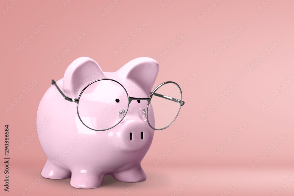 Piggy bank in glasses on background Piggy bank in glasses on background