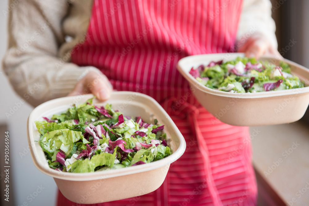 Chef holding salad in to go containers Chef holding salad in to go containers