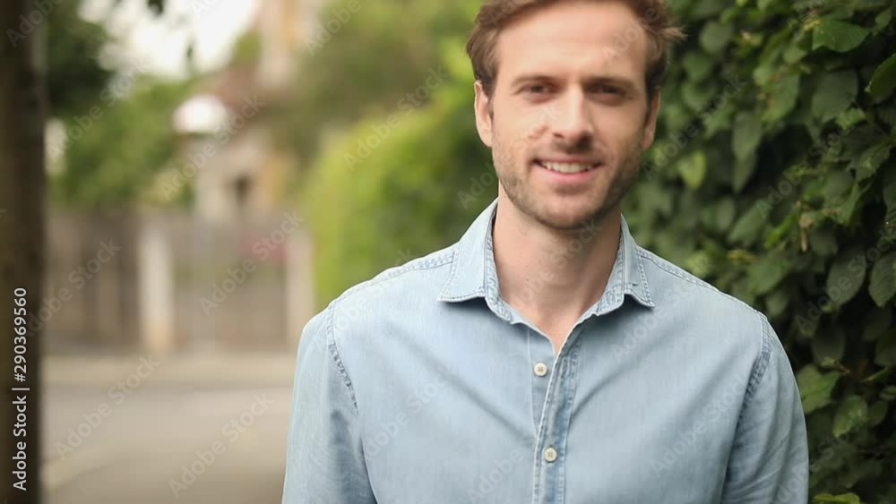 closeup shot of a smiling young casual man posing for the camera outdoor closeup shot of a smiling young casual man posing for the camera outdoor