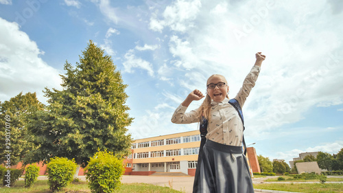 Happy eleven year old schoolgirl jumps in happy emotions.