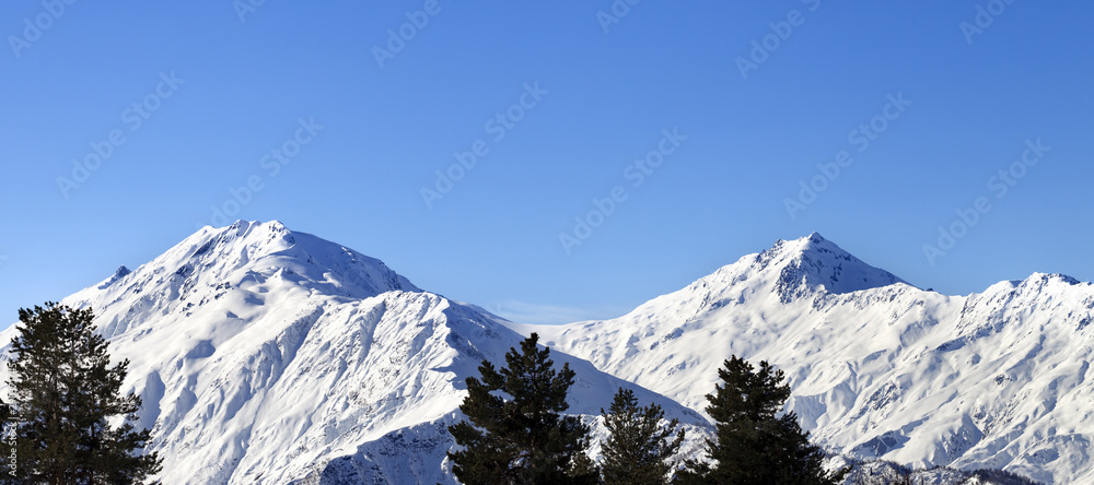 Snowy mountains and blue clear sky at nice sun morning