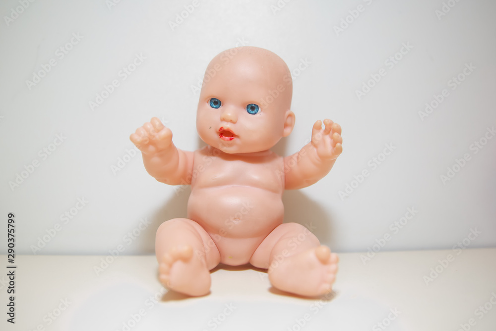Cute little naked baby doll with blue eyes sitting or walking . Copy space.There is no clothes on the doll . baby doll isolated in white background closeup . Doll white background no clothes . Cute little naked baby doll with blue eyes sitting or walking . Copy space.There is no clothes on the doll . baby doll isolated in white background closeup . Doll white background no clothes .