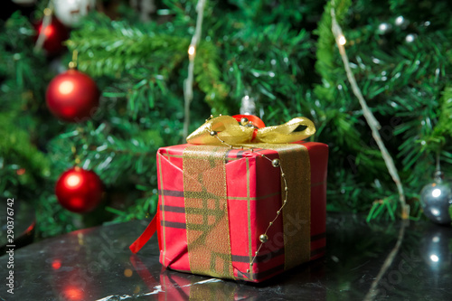 Gifts under the Christmas tree decorated with golg ribbon and bow. Red Christmas gift . Beautiful Christmas tree with red balls. photo