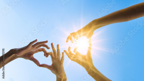 Hände von Mädchen / Frau bilden ein Herz aus ihren Fingern - Hintergrund blauer Himmel mit Sonne © Corri Seizinger